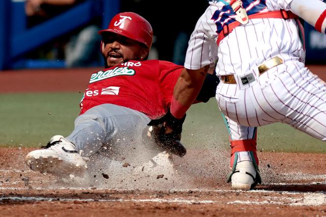 Federales de Chiriqui’s #7 Johan Camargo dives toward home plate as Leones del Escogido’s #25 Michael De La Cruz catches the ball during the third inning of the Caribbean Series baseball tournament seventh game between Panama's Federales de Chiriqui and Dominican Republic's Leones del Escogido at the Panamerican Stadium in Jalisco, Mexico, on February 4, 2026. (Photo by Ulises Ruiz / AFP)