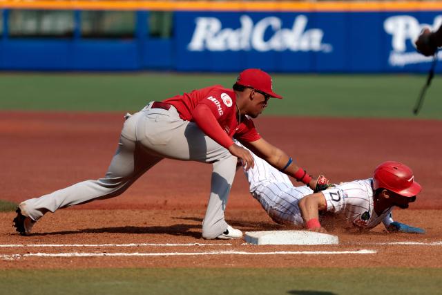 Leones del Escogido's #37 Erik Gonzalez (R) dives first base as Federales de Chiriqui's #18 Jean Arnaez catches the ball during the fourth inning of the Caribbean Series baseball tournament seventh game between Panama's Federales de Chiriqui and Dominican Republic's Leones del Escogido at the Panamerican Stadium in Jalisco, Mexico, on February 4, 2026. (Photo by Ulises Ruiz / AFP)