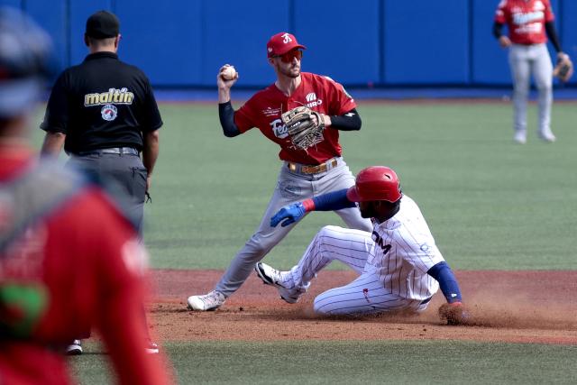 Leones del Escogido's #10 Franchy Cordero dives second base as Federales de Chiriqui's #3 Austin Dennis catches the ball during the fourth inning of the Caribbean Series baseball tournament seventh game between Panama's Federales de Chiriqui and Dominican Republic's Leones del Escogido at the Panamerican Stadium in Jalisco, Mexico, on February 4, 2026. (Photo by Ulises Ruiz / AFP)