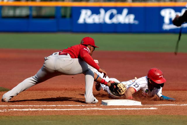 Leones del Escogido's #37 Erik Gonzalez (R) dives first base as Federales de Chiriqui's #18 Jean Arnaez catches the ball during the fourth inning of the Caribbean Series baseball tournament seventh game between Panama's Federales de Chiriqui and Dominican Republic's Leones del Escogido at the Panamerican Stadium in Jalisco, Mexico, on February 4, 2026. (Photo by Ulises Ruiz / AFP)