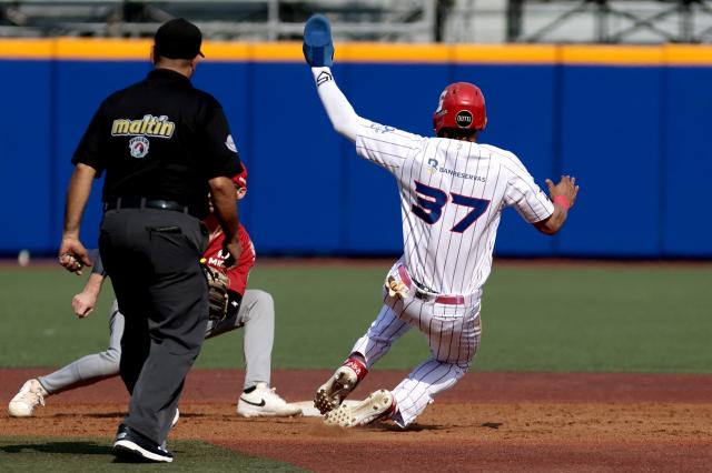 Leones del Escogido's #37 Erik Gonzalez dives second base as Federales de Chiriqui's #3 Austin Dennis catches the ball during the fourth inning of the Caribbean Series baseball tournament seventh game between Panama's Federales de Chiriqui and Dominican Republic's Leones del Escogido at the Panamerican Stadium in Jalisco, Mexico, on February 4, 2026. (Photo by Ulises Ruiz / AFP)
