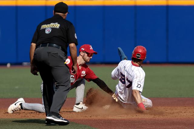 Federales de Chiriqui's #3 Austin Dennis dives second base as Leones del Escogido's #37 Erik Gonzalez catches the ball during the fourth inning of the Caribbean Series baseball tournament seventh game between Panama's Federales de Chiriqui and Dominican Republic's Leones del Escogido at the Panamerican Stadium in Jalisco, Mexico, on February 4, 2026. (Photo by Ulises Ruiz / AFP)