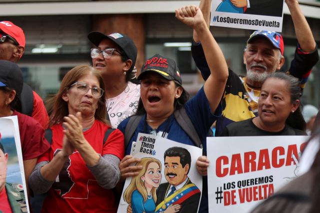 Supporters gesture as they hold signs depicting ousted President Nicolas Maduro during a march by 'Chavismo' supporters to commemorate the 34th anniversary of a coup attempt by Hugo Chavez, in Maracay, Aragua state, Venezuela, on February 4, 2026. (Photo by Pedro MATTEY / AFP)