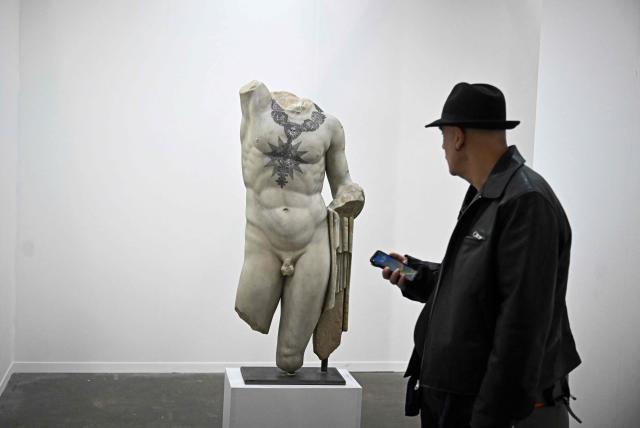 A man looks at a sculpture on the first day of Mexico Art Week, the biggest Art fair in Latin America, drawing artists and collectors from all over the world in Mexico City on February 4, 2026. The annual fair runs from February 4 until February 8, 2026. (Photo by Carl de Souza / AFP)