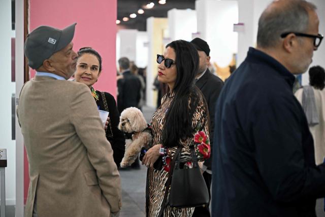 Attendees converse on the first day of Mexico Art Week, the biggest Art fair in Latin America, drawing artists and collectors from all over the world in Mexico City on February 4, 2026. The annual fair runs from February 4 until February 8, 2026. (Photo by Carl de Souza / AFP)