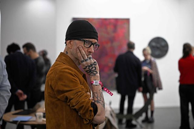 An attendee observes a work of art on the first day of Mexico Art Week, the biggest Art fair in Latin America, drawing artists and collectors from all over the world in Mexico City on February 4, 2026. The annual fair runs from February 4 until February 8, 2026. (Photo by Carl de Souza / AFP)