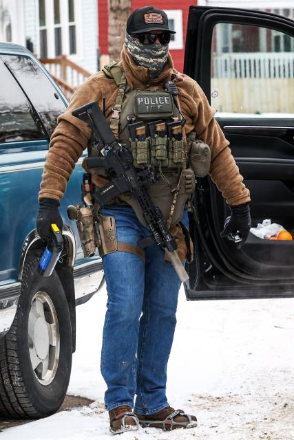 A masked US federal immigration agent wearing a "Police ICE" badge patrols in Minneapolis, Minnesota, on February 4, 2026. US border czar Tom Homan on February 4 announced the removal of 700 immigration enforcement personnel from Minnesota after weeks of operations and the fatal shooting of two protesters that sparked outrage. Homan said the move would take effect "immediately," citing increased cooperation with local authorities, without specifying whether they would be taken out of the city of Minneapolis or elsewhere in the state. (Photo by Charly TRIBALLEAU / AFP)