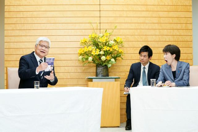TSMC Chairman CC Wei (L) introduces a book written by Japanese Prime Minister Sanae Takaichi (R) during their meeting at the Prime Minister's Office in Tokyo on February 5, 2026. (Photo by Kazuhiro NOGI / POOL / AFP)