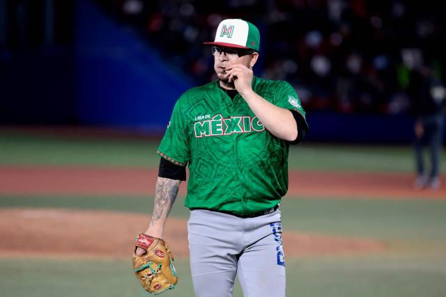 Tomateros de Culiacan's #9 Faustino Carrera kisses a medal after a pitch in the third inning of the Caribbean Series baseball tournament eight game between Mexico's Tomateros de Culiacan and Mexico's Charros de Jalisco at the Panamerican Stadium in Jalisco, Mexico, on February 4, 2026. (Photo by Ulises Ruiz / AFP)