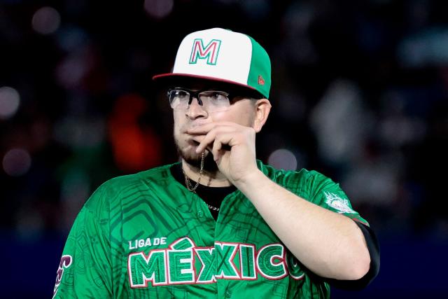 Tomateros de Culiacan's #9 Faustino Carrera kisses a medal after a pitch in the fourth inning of the Caribbean Series baseball tournament eight game between Mexico's Tomateros de Culiacan and Mexico's Charros de Jalisco at the Panamerican Stadium in Jalisco, Mexico, on February 4, 2026. (Photo by Ulises Ruiz / AFP)