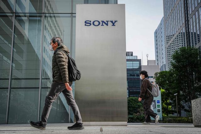 People walk past the Sony headquarters in Tokyo on February 5, 2025. Japanese giant Sony on February 5, 2026 hiked its full-year net profit forecast thanks to strong performances in its video games and music divisions. (Photo by Yuichi YAMAZAKI / AFP)
