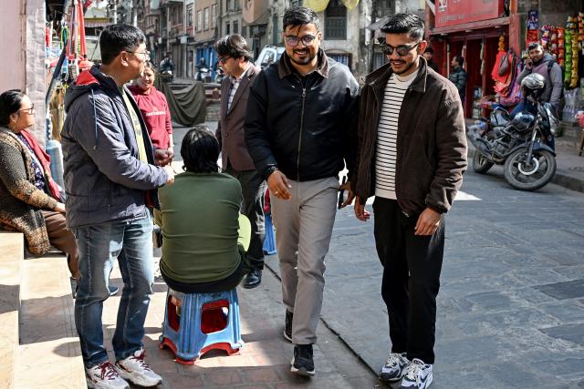 This photograph taken on February 3, 2026 shows Nepali Congress party election candidate Sachin Timalsena (C) walking along with his party workers across a market area in Kathmandu. Young election candidates are hoping to ride the wave of anger that toppled the previous government in Nepal, with 30 percent of the total registered for direct election aged under 40. The Himalayan country heads into landmark elections on March 5 -- the first since the deadly youth-led anti-corruption protest in 2025 spearheaded by protesters under the loose "Gen Z" umbrella title. (Photo by Prakash MATHEMA / AFP)