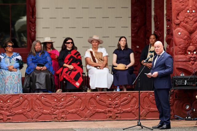New Zealand's Prime Minister Christopher Luxon (R) speaks at a ceremony commemorating Waitangi Day in Waitangi on February 5, 2026. New Zealand's Prime Minister Christopher Luxon was heckled by a Maori crowd on February 5 during a speech marking national Waitangi Day celebrations, an annual political gathering that gives Indigenous tribes a chance to air grievances. (Photo by Ben STRANG / AFP)