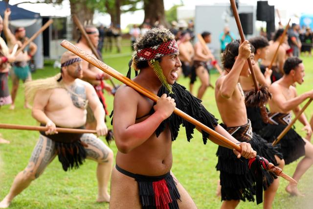 Maori warriors welcome dignitaries onto the Waitangi Treaty Grounds during a ceremony commemorating Waitangi Day in Waitangi on February 5, 2026. New Zealand's Prime Minister Christopher Luxon was heckled by a Maori crowd on February 5 during a speech marking national Waitangi Day celebrations, an annual political gathering that gives Indigenous tribes a chance to air grievances. (Photo by Ben STRANG / AFP)