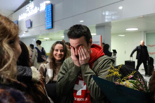 French national Tom Felix is greeted by friends and relatives as he arrives at Roissy-Charles de Gaulle Airport after he was acquitted on eight drug-related charges at the Malaysian High Court, on the outskirts of Paris, on February 5, 2026. A Malaysian court acquitted on February 3 the French national who was facing the death penalty on eight drug-related charges, freeing him after nearly two and a half years in detention. (Photo by GEOFFROY VAN DER HASSELT / AFP)