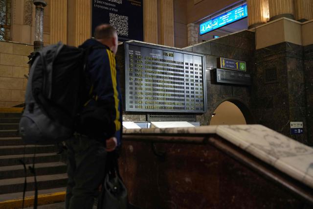 A man looks at a train timetable at the Kiev central train station on February 4, 2026, amid the Russian invasion of Ukraine. (Photo by OLEKSII FILIPPOV / AFP)