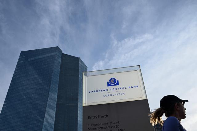 (FILES) A woman runs past the European Central Bank (ECB) headquarters in Frankfurt am Main, western Germany, on December 18, 2025, prior to the meeting on the Eurozone's monetary policy,. A rising euro and falling inflation will present fresh challenges for the European Central Bank at its meeting on February 5, 2026, potentially reviving debate about if and when policymakers should start cutting interest rates. (Photo by Kirill KUDRYAVTSEV / AFP)