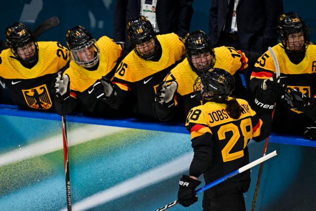 Germany's defender #28 Katarina Jobst-Smith (front R) celebrates with temmates after scoring her team first goal during the women's preliminary round Group B Ice Hockey match between Sweden and Germany at the Milano Rho Ice Hockey Arena during the Milano Cortina 2026 Winter Olympic Games, in Milan, on February 5, 2026. (Photo by Alexander NEMENOV / AFP)