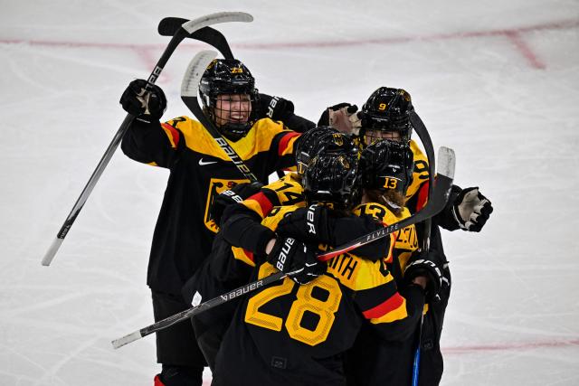 Germany's defender #28 Katarina Jobst-Smith (front C) celebrates with teammates after scoring her team first goal during the women's preliminary round Group B Ice Hockey match between Sweden and Germany at the Milano Rho Ice Hockey Arena during the Milano Cortina 2026 Winter Olympic Games, in Milan, on February 5, 2026. (Photo by Alexander NEMENOV / AFP)