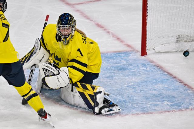 Germany's defender #28 Katarina Jobst-Smith (unseen) shoots her team first goal past Sweden's goalkeeper #01 Ebba Svensson Traff during the women's preliminary round Group B Ice Hockey match between Sweden and Germany at the Milano Rho Ice Hockey Arena during the Milano Cortina 2026 Winter Olympic Games, in Milan, on February 5, 2026. (Photo by Alexander NEMENOV / AFP)