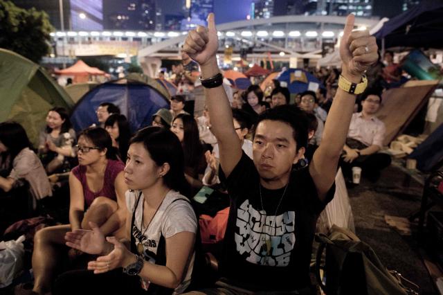 (FILES) Pro-democracy demonstrators react as they watch a live transmission on a giant screen of talks with leaders of the Hong Kong Federation of Students and Hong Kong authorities, in the Admiralty district of Hong Kong on October 21, 2014. A pro-democracy student organisation in Hong Kong said on February 5, 2026 its members had decided to dissolve, citing "increasingly severe pressures". Established in 1958, the Hong Kong Federation of Students (HKFS) played a leading role in mobilising the Chinese city's student community to participate in once-vibrant social movements. (Photo by NICOLAS ASFOURI / AFP)
