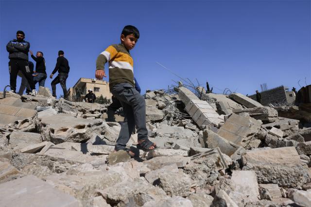 A Palestinian boy walks along the debris from homes and shops after bulldozers protected by Israeli security forces demolished residential buildings belonging to Palestinian families in Beit Aawa, west the Israeli-occupied West Bank city of Hebron on February 5, 2026. Israel, whose army has occupied the West Bank since 1967, regularly demolishes the homes of Palestinians accused of carrying out deadly attacks against Israelis and of not having construction permits issued by Israel. The government defends the deterrent effect of these demolitions, but critics denounce the practice as a form of collective punishment that leaves families homeless. (Photo by HAZEM BADER / AFP)