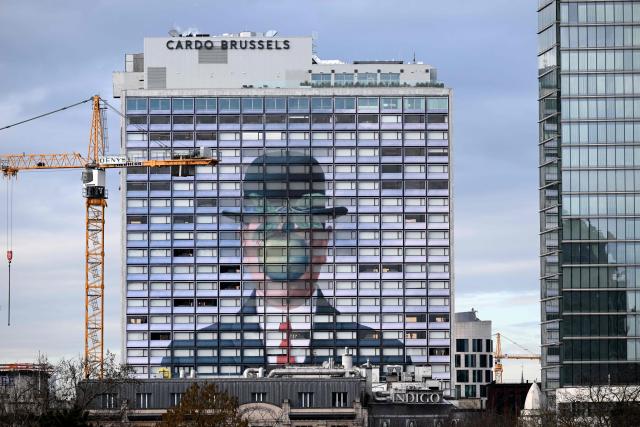 This photograph shows a reproduction of the painting “The Son of Man” by Belgian surrealist painter Rene Magritte on the facade of a hotel in Brussels, on February 4, 2026. (Photo by Nicolas TUCAT / AFP)