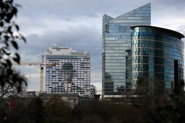 This photograph shows a reproduction of the painting “The Son of Man” by Belgian surrealist painter Rene Magritte on the facade of a hotel in Brussels, on February 4, 2026. (Photo by Nicolas TUCAT / AFP)