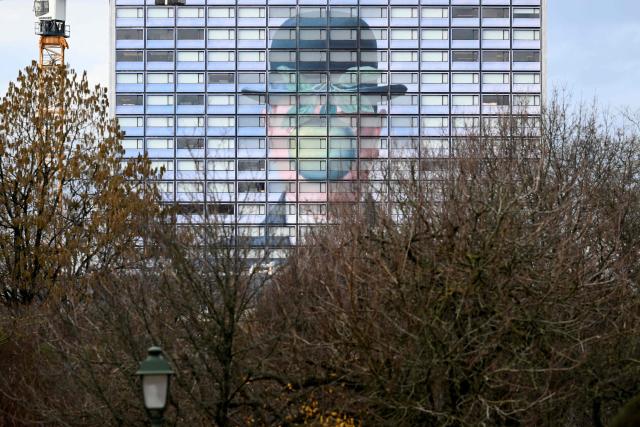 This photograph shows a reproduction of the painting “The Son of Man” by Belgian surrealist painter Rene Magritte on the facade of a hotel in Brussels, on February 4, 2026. (Photo by Nicolas TUCAT / AFP)