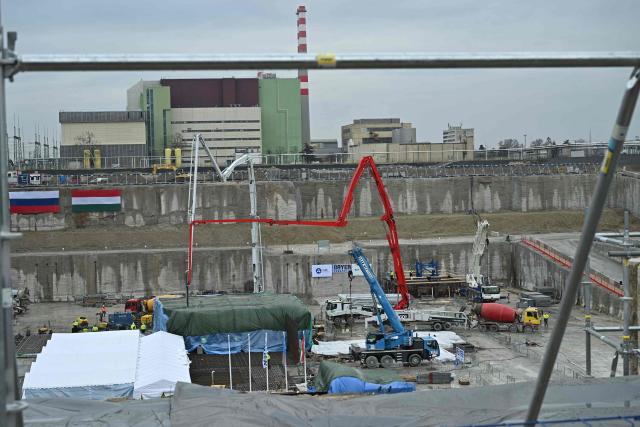 An overview shows Hungarian (R) and Russian (L) national flags on a wall, workers and vehicles at the Paks II site near the city of Paks, southern Hungary, on February 5, 2026, as concreting begins on the foundation plate of the first technological building on the nuclear island of Unit 5, officially marking the start of the physical construction of Paks II. Workers poured concrete for a new reactor near Hungary's sole nuclear plant beginning a contentious expansion project led by Russia's Rosatom following a decade of delays.
Hungary struck an agreement with Russia in 2014 involving a 10 billion euro ($11 billion) loan deal to build two reactors at the Paks plant south of Budapest. (Photo by Attila KISBENEDEK / AFP)