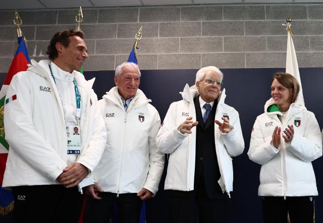 Italian President Sergio Mattarella (2nd R), wearing an Italian delegation Olympic jacket as he visits the Olympic Village, speaks as President of the Italian National Olympic Committee (CONI) Luciano Buonfiglio (2nd L) reacts, ahead of the Milano Cortina 2026 Winter Olympic Games in Milan, on February 5, 2026. (Photo by Yara Nardi / POOL / AFP)