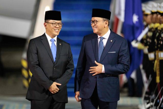 Indonesia's Foreign Minister Sugiono (L) and Danantara Indonesia Chief Executive Officer Rosan Roeslani speak after welcoming Australia's Prime Minister Anthony Albanese at the Halim Perdanakusuma International Airport in Jakarta on February 5, 2026. (Photo by Yasuyoshi CHIBA / AFP)