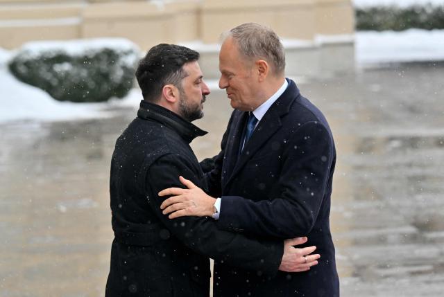 Ukrainian President Volodymyr Zelensky (L) and Poland's Prime Minister Donald Tusk (R) embrace ahead of their meeting at the Mariinskyi Palace in Kyiv, on February 5, 2026. (Photo by Sergei SUPINSKY / AFP)