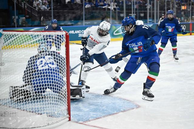 France's forward #08 Jade Barbirati (C) vies for the puck with Italy's forward #11 Justine Reyes (R) and Italy's goalkeeper #25 Martina Fedel during the women's preliminary round group B Ice Hockey match between Italy and France at the Milano Santagiulia Ice Hockey Arena during the Milano Cortina 2026 Winter Olympic Games in Milan, on February 5, 2026. (Photo by JULIEN DE ROSA / AFP)