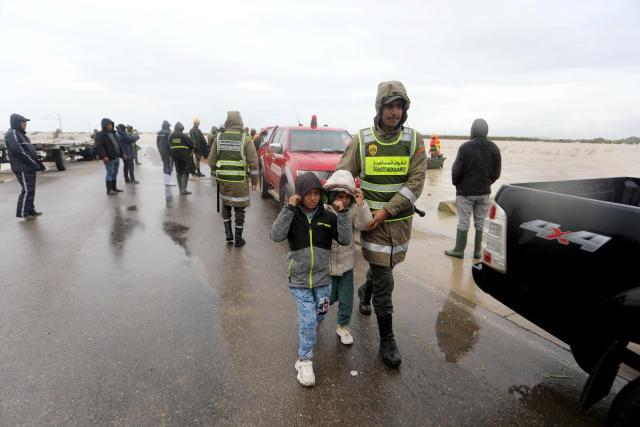 Members of the Auxillary Forces help evacuate children from flood waters in the Sidi Kacem region, in northwestern Morocco on February 5, 2026. More than 100,000 people have been evacuated since January 30, 2026, in the northwest of the country, mainly as a precaution, following exceptional rainfall that led authorities to place several provinces under weather alert. (Photo by AFP)