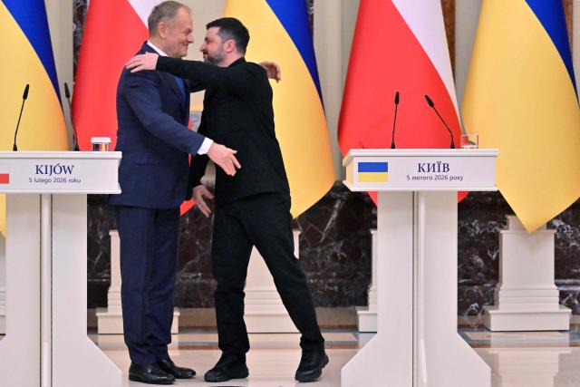 Ukraine's President Volodymyr Zelensky (R) embraces Poland's Prime Minister Donald Tusk at the end of a press conference at the Mariinskyi Palace in Kyiv on February 5, 2026, amid the Russian invasion of Ukraine. (Photo by Sergei SUPINSKY / AFP)