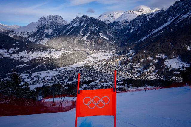 This photograph taken on February 5, 2026, shows the Olympic rings on a downhill flag and the Stelvio Alpine Skiing Centre, hosting to the men's Alpine skiing events of the Milano Cortina 2026 Winter Olympic Games in Bormio (Valtellina) on February 5, 2026. (Photo by DIMITAR DILKOFF / AFP)