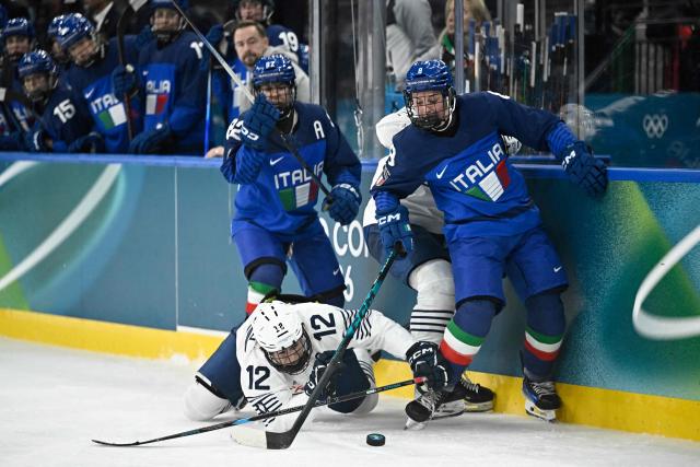 Italy's forward #08 Anna Caumo (R) and France's forward #12 Estelle Duvin vie for the puck during the women's preliminary round group B Ice Hockey match between Italy and France at the Milano Santagiulia Ice Hockey Arena during the Milano Cortina 2026 Winter Olympic Games in Milan, on February 5, 2026. (Photo by JULIEN DE ROSA / AFP)