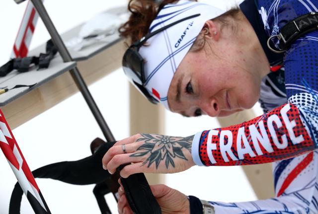 This photograph shows a view of France's Lou Jeanmonnot's hand with a ring and a tattoo, and with the word France written on her sleeve as she takes part a training session at the biathlon venue prior to the Milano Cortina 2026 Winter Olympic Games in Antholz, northern Italy, on February 5, 2026. (Photo by FRANCK FIFE / AFP)