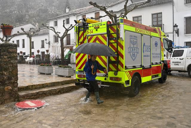A person crosses a flooded street in Grazalema, southern Spain, on February 5, 2026, amid Storm Leonardo. Spain today lifted its highest weather alert for torrential rain in the southern region of Andalusia, where a woman went missing, a day after the storm killed one in Portugal. Storm Leonardo dumped more than 40 centimetres (15 inches) of rain in some Andalusian districts yesterday, forcing the evacuation of thousands, paralysing rail and road transport and shutting schools. The downpours, which came after a storm killed five people and left hundreds injured in neighbouring Portugal last week, are examples of extreme weather that scientists say climate change is worsening. (Photo by Jorge GUERRERO / AFP)