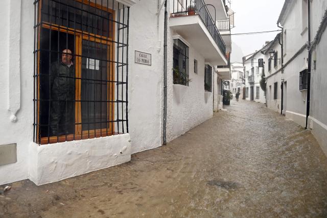 A man observes a flooded street in Grazalema, southern Spain, on February 5, 2026, amid Storm Leonardo. Spain today lifted its highest weather alert for torrential rain in the southern region of Andalusia, where a woman went missing, a day after the storm killed one in Portugal. Storm Leonardo dumped more than 40 centimetres (15 inches) of rain in some Andalusian districts yesterday, forcing the evacuation of thousands, paralysing rail and road transport and shutting schools. The downpours, which came after a storm killed five people and left hundreds injured in neighbouring Portugal last week, are examples of extreme weather that scientists say climate change is worsening. (Photo by Jorge GUERRERO / AFP)