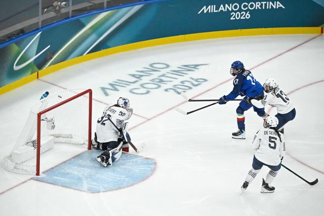 Italy's forward #17 Matilde Fantin (2L) scores the 3-1 goal past France's goalkeeper #32 Alice Philbert (L) during the women's preliminary round group B Ice Hockey match between Italy and France at the Milano Santagiulia Ice Hockey Arena during the Milano Cortina 2026 Winter Olympic Games in Milan, on February 5, 2026. (Photo by JULIEN DE ROSA / AFP)