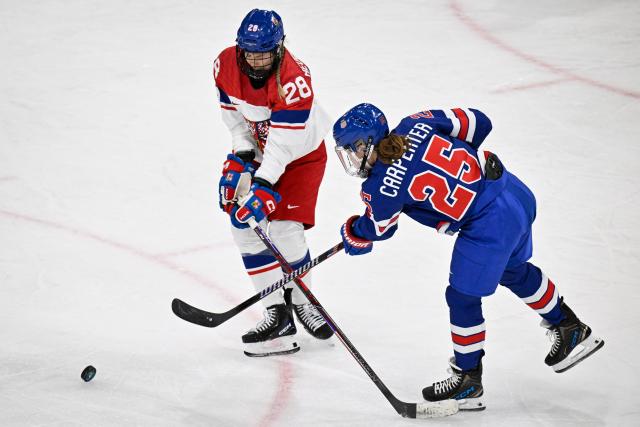Czech Republic's defender #28 Noemi Neubauerova (L) challenges US' forward #25 Alex Carpenter (R) during the women's preliminary round Group A Ice Hockey match between USA and Czech Republic at the Milano Rho Ice Hockey Arena during the Milano Cortina 2026 Winter Olympic Games in Milan, on February 5, 2026. (Photo by Alexander NEMENOV / AFP)