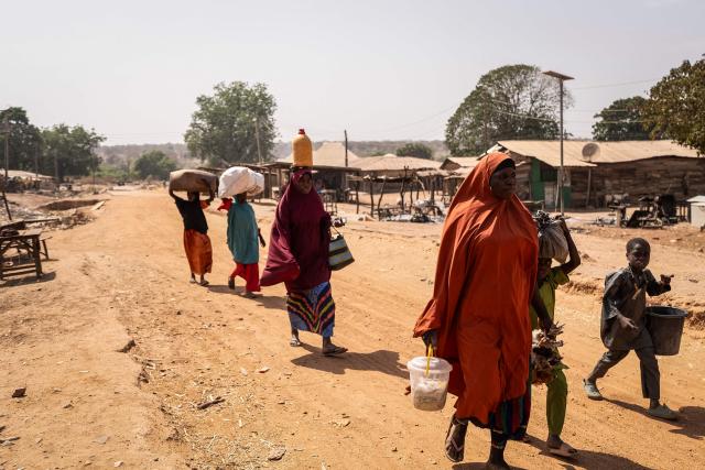 Residents carry their belongings as they flee the area following the attack in Woro, Kwara State, on February 5, 2026. Details are still emerging from the attack in Kwara State, but it is one of the country's deadliest in recent months. According to the Red Cross, the death toll stands at 162 people, and the search for bodies is ongoing. (Photo by Light Oriye Tamunotonye / AFP)