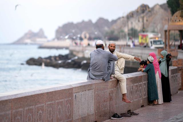 Two men sit along the corniche in Oman's capital Muscat on February 5, 2026. (Photo by Loic VENANCE / AFP)