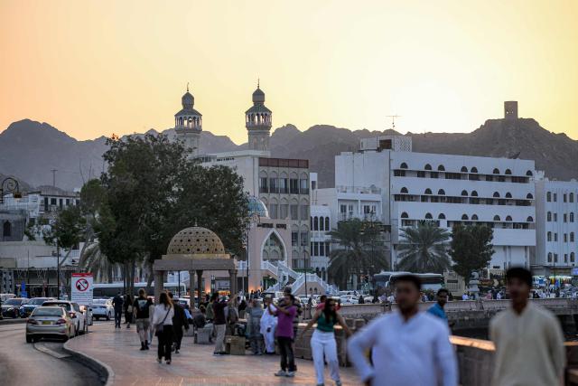 People walk along the corniche in Oman's capital Muscat on February 5, 2026. (Photo by Loic VENANCE / AFP)