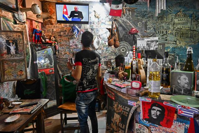 A man looks at Cuba's President Miguel Diaz-Canel speaking on the National Television, in Havana on February 5, 2026. Cuba is prepared to hold dialogue with the United States but not under pressure, President Miguel Diaz-Canel insisted Thursday after months of threats from US President Donald Trump. (Photo by YAMIL LAGE / AFP)