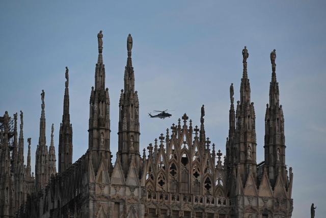 A helicopter flies above the Duomo in central Milan ahead of Milano Cortina 2026 Olympic Games, on February 5, 2026. (Photo by Daniel MUNOZ / AFP)