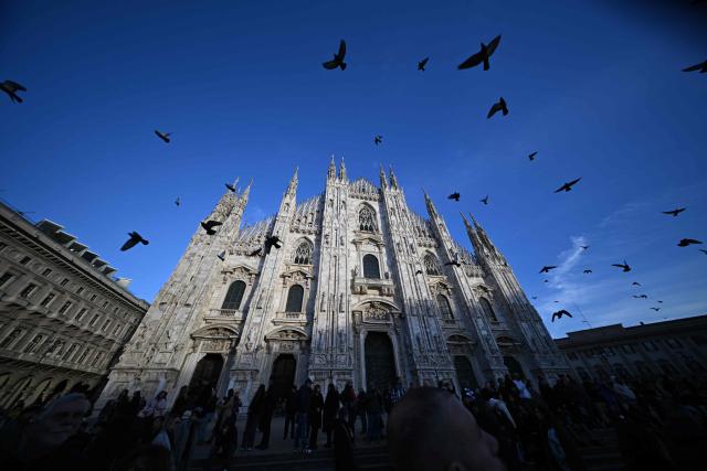 Pigeons fly at Piazza Duomo in central Milan ahead of Milano Cortina 2026 Olympic Games, on February 5, 2026. (Photo by Daniel MUNOZ / AFP)