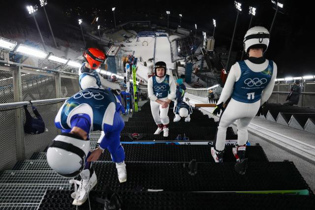 Athletes including Ukraine's Vitaliy Kalinichenko (C) prepare for a jump during the men's ski jumping normal hill training of the Milano Cortina 2026 Winter Olympic Games at Predazzo Ski Jumping Stadium in Predazzo (Val di Fiemme), on February 5, 2026. (Photo by Anne-Christine POUJOULAT / AFP)